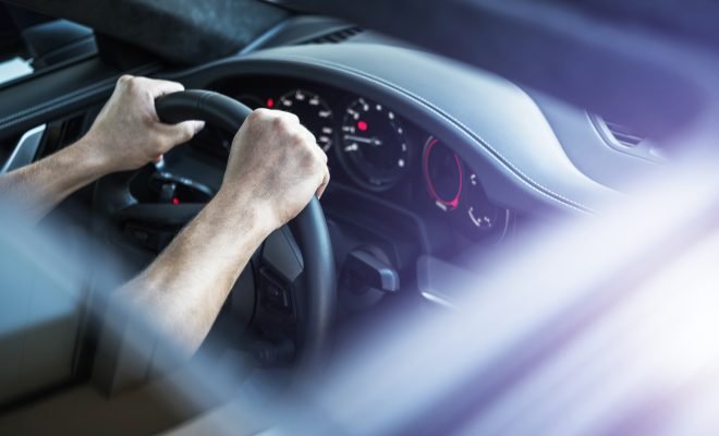 Driver Behind Supercar Steering Wheel